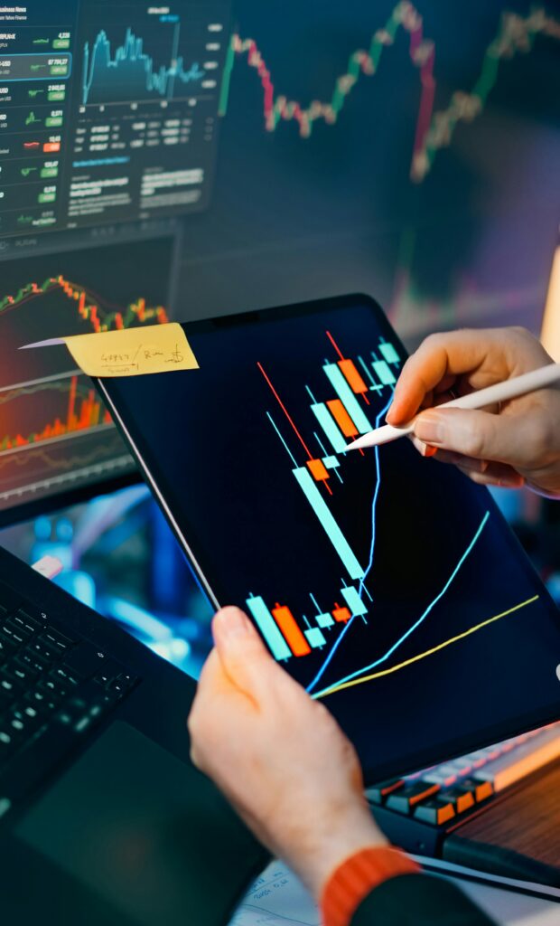 Person using a tablet to analyze financial charts for trading insights. Perfect for finance and technology themes.